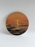 Original round ocean sunset oil painting featuring glowing golden reflections over calm coastal waters on a 12-inch round canvas by Shreya Chandra.